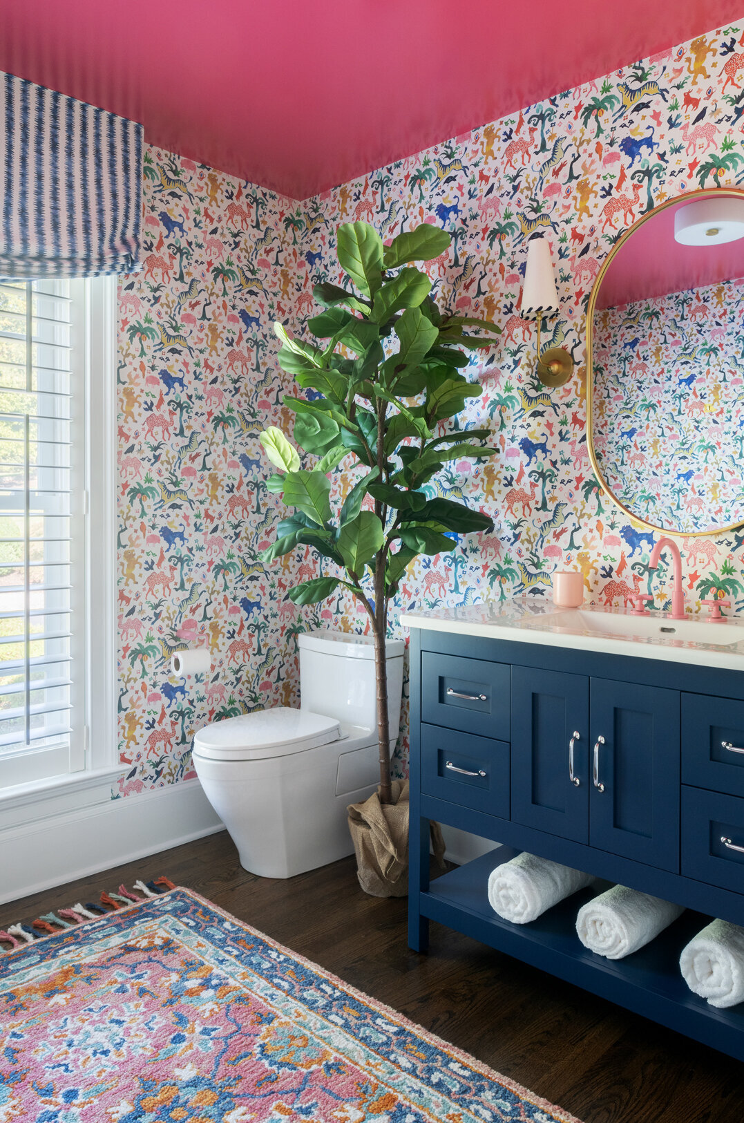 colorful animal patterned bathroom with navy blue under sink cabinet and pink ceiling