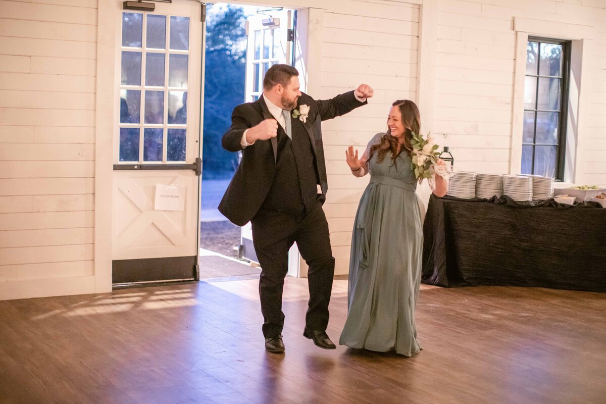 bridesmaid and groomsman dance silly at reception entrance wedding near Austin