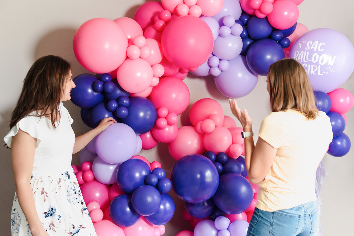 woman surprised by a  beautiful balloon garland