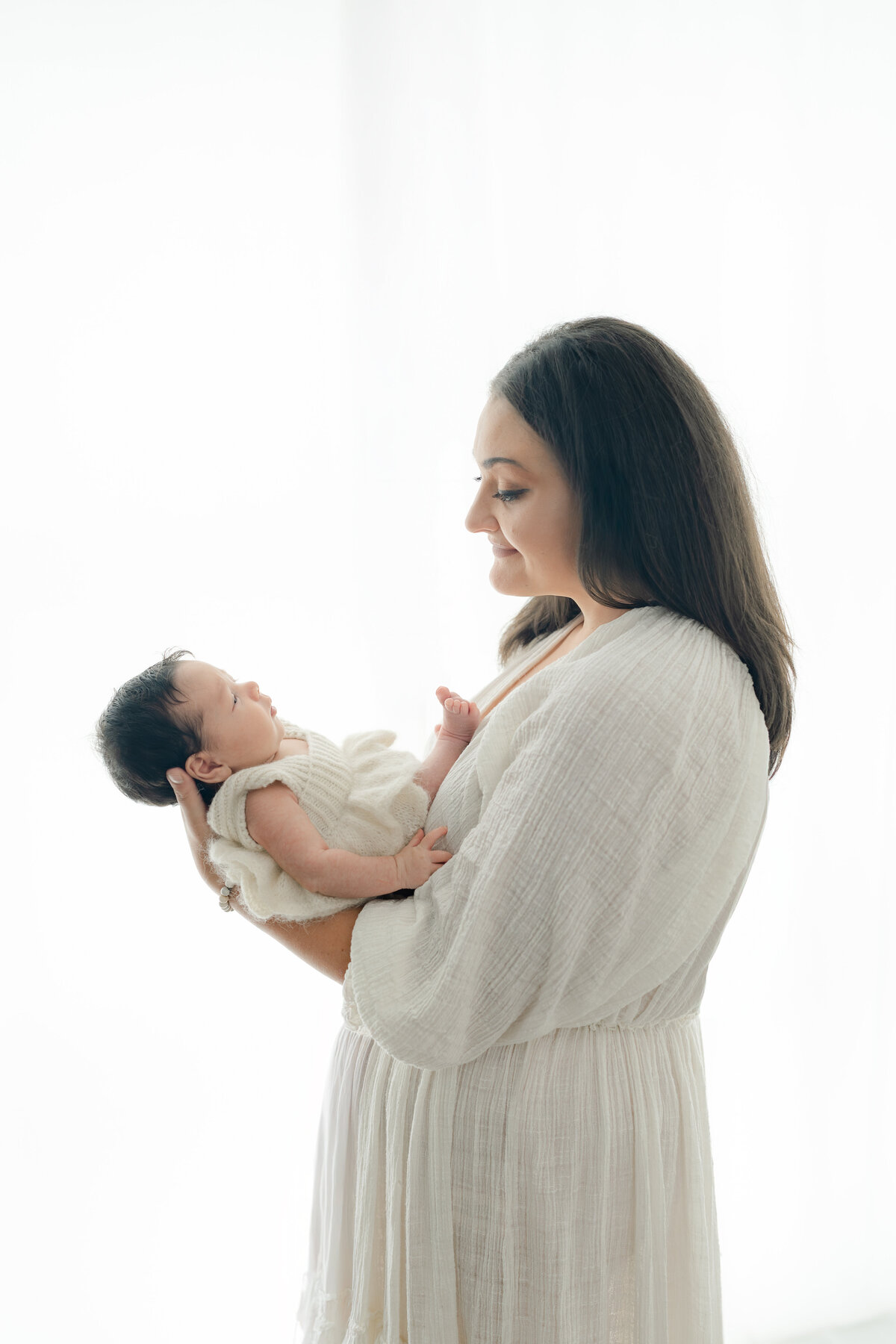 Mom holding baby during natural light Barrie newborn photography session 