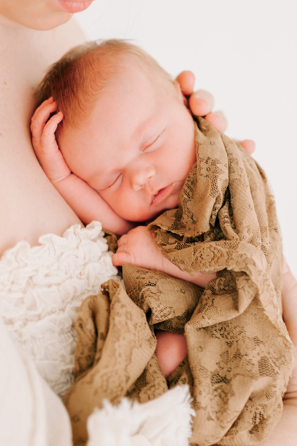 Springfield MO newborn photographer captures sleeping baby girl in lace blanket on moms chest