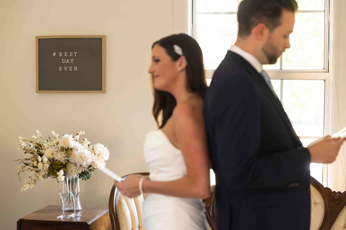 Bride and groom sharing private vows standing back to back