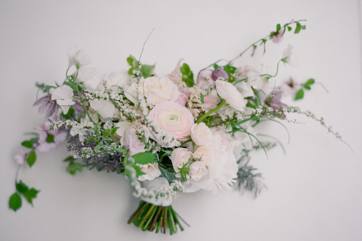 Close-up of a springtime bouquet of pastel pink and purple flowers and greenery.