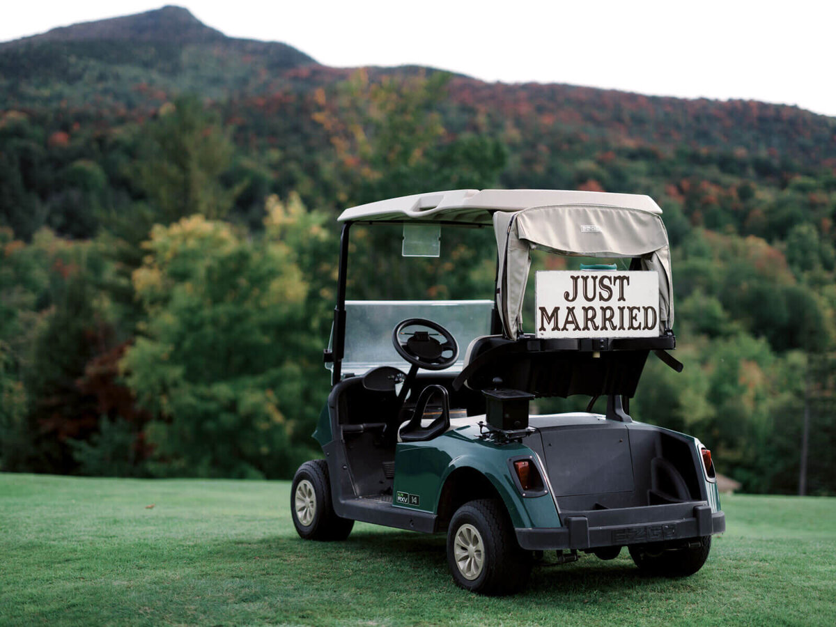 A golf cart with "Just Married" sign at the back, mountains in the background, at The Ausable Club,NY. Image by Jenny Fu Studio.