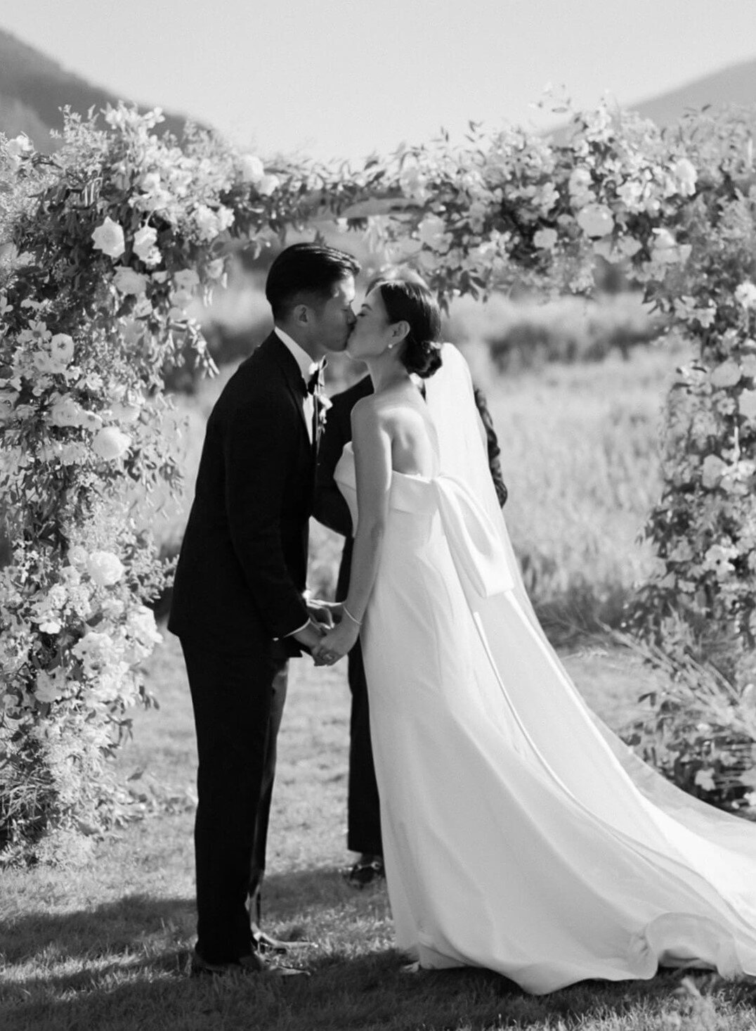 Bride and groom sharing a kiss after their wedding ceremony at Aspen Meadows Resort, surrounded by nature and a scenic backdrop.