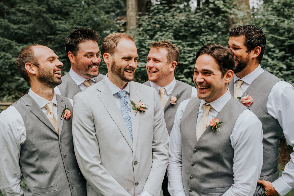 Groomsmen dressed in gray vests.