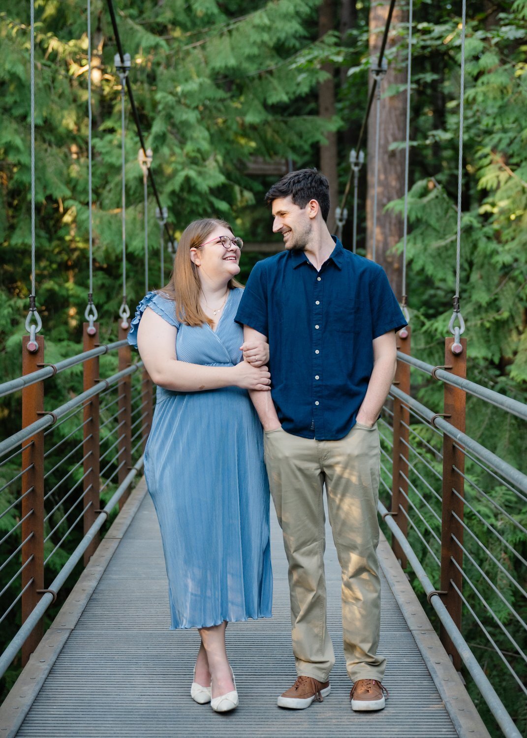 couple smile on suspension bridge in bellevue washington