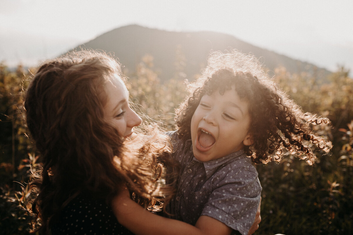 mother and son in golden light on asheville mountain top