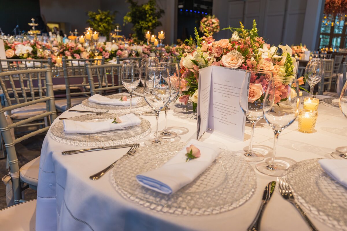 A wedding reception table with white and pink flowers as decorations.