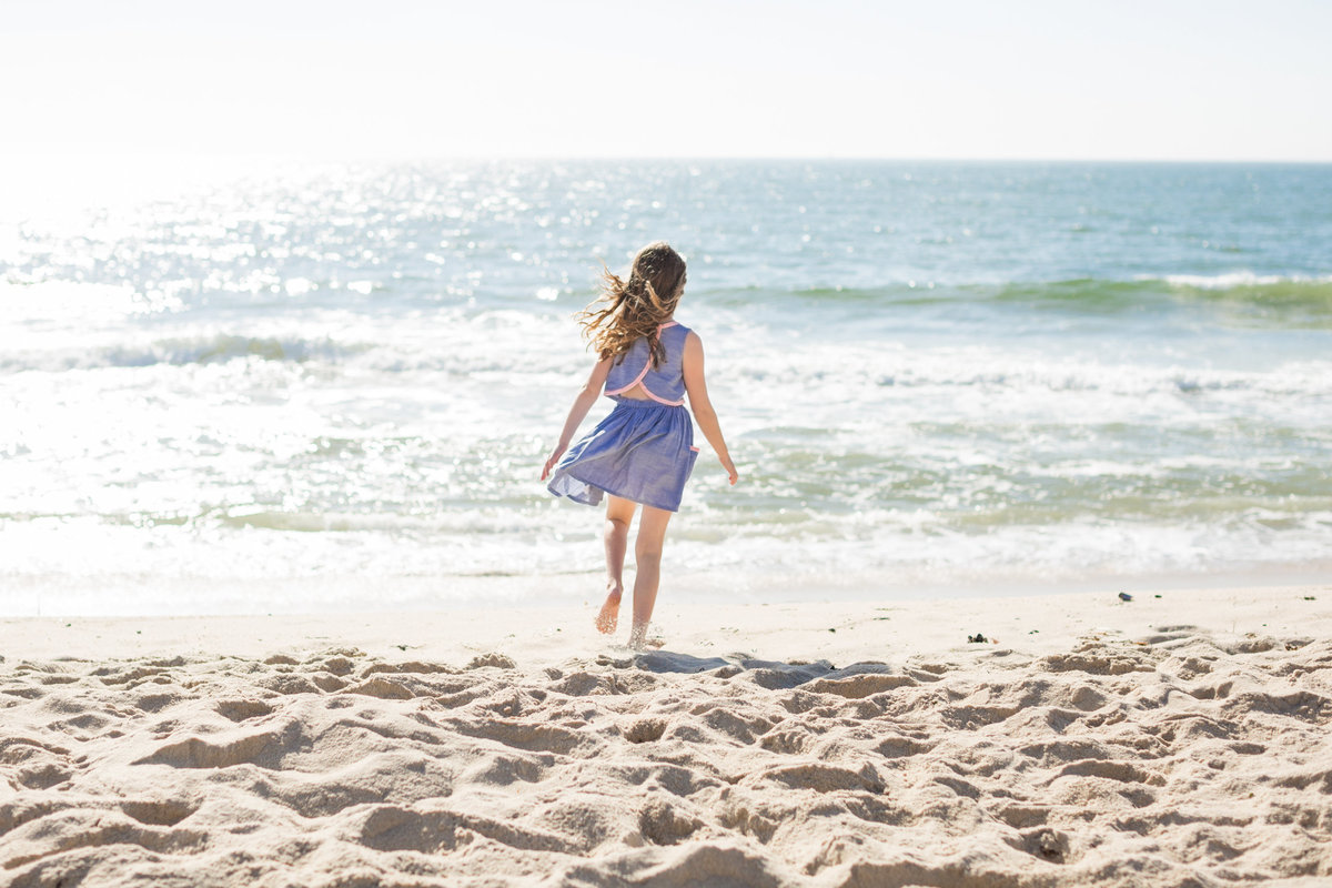 girl walking towards the water on the beach