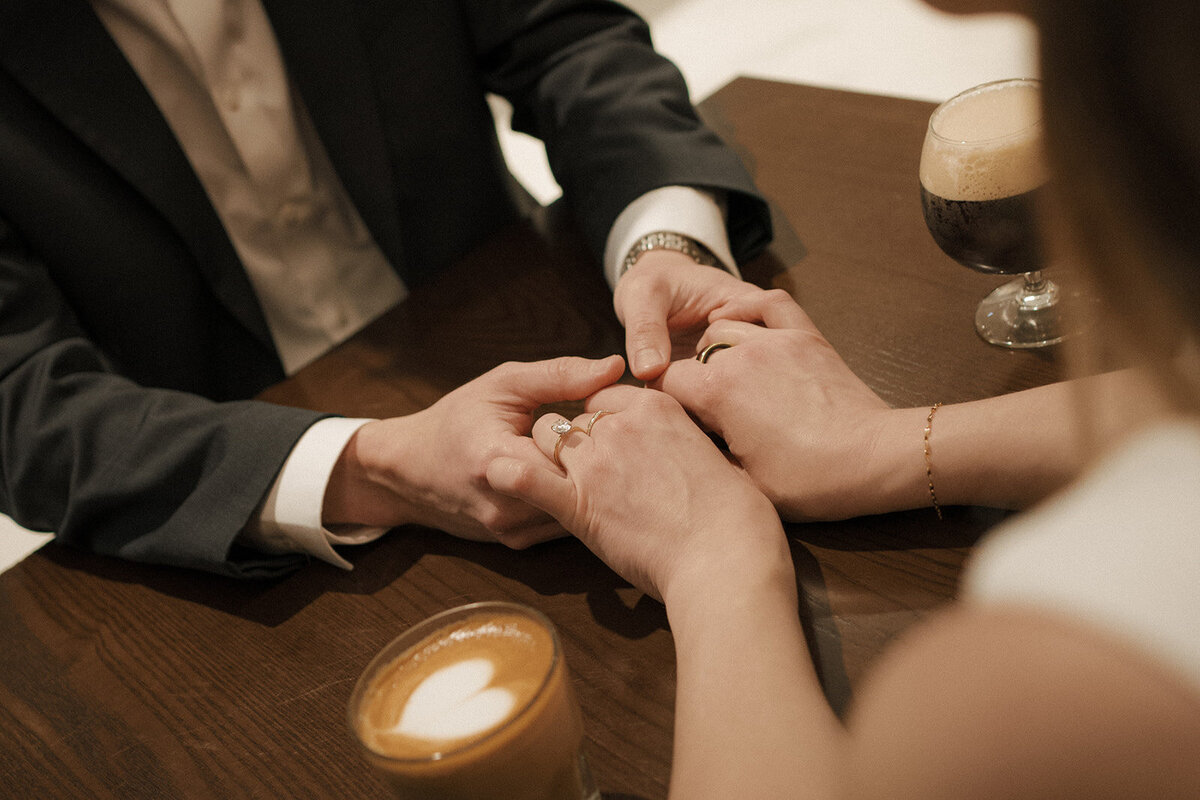 close up couple holding hands engagement ring heart drink