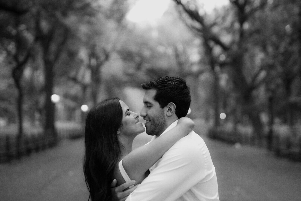 Black and white headshot of the engaged couple with their noses almost touching at Central Park, NYC. Image by Jenny Fu Studio.