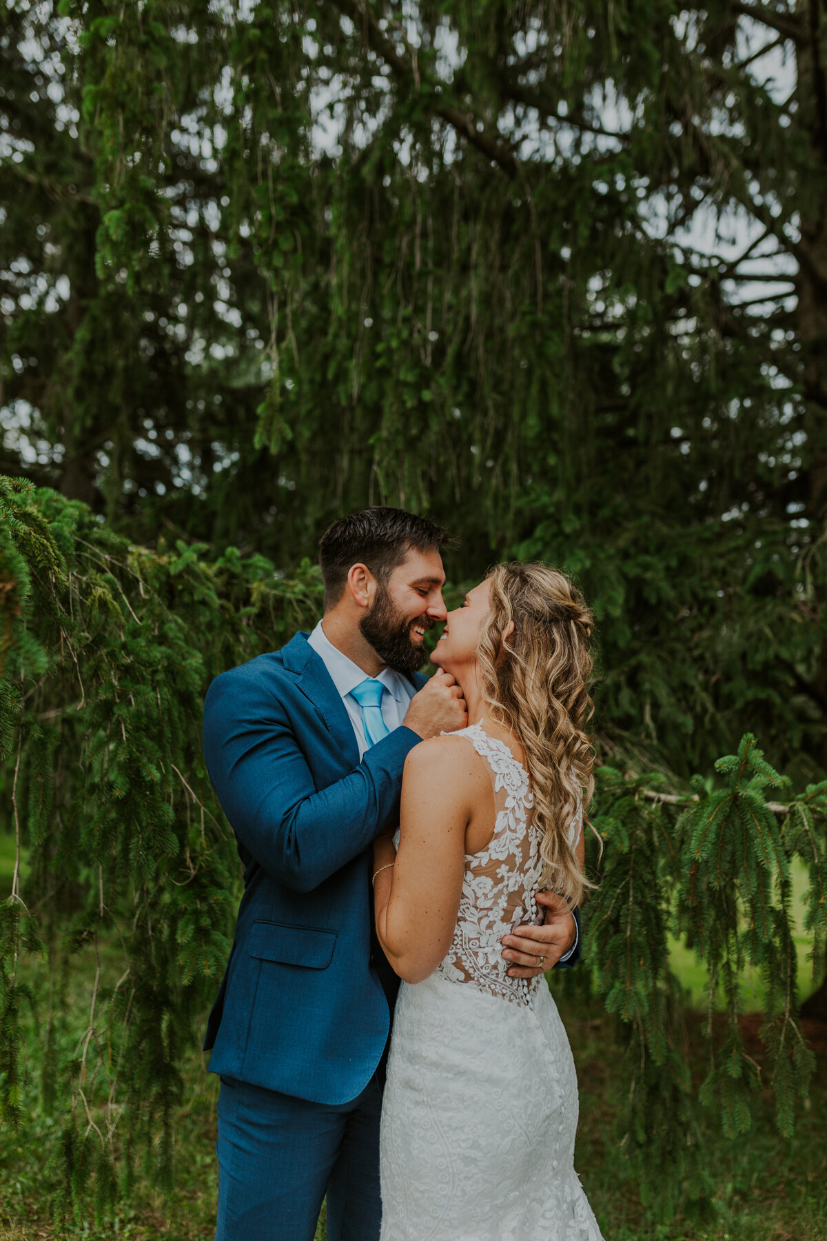 Couple sharing a kiss in a lush outdoor setting, Indiana engagement.
