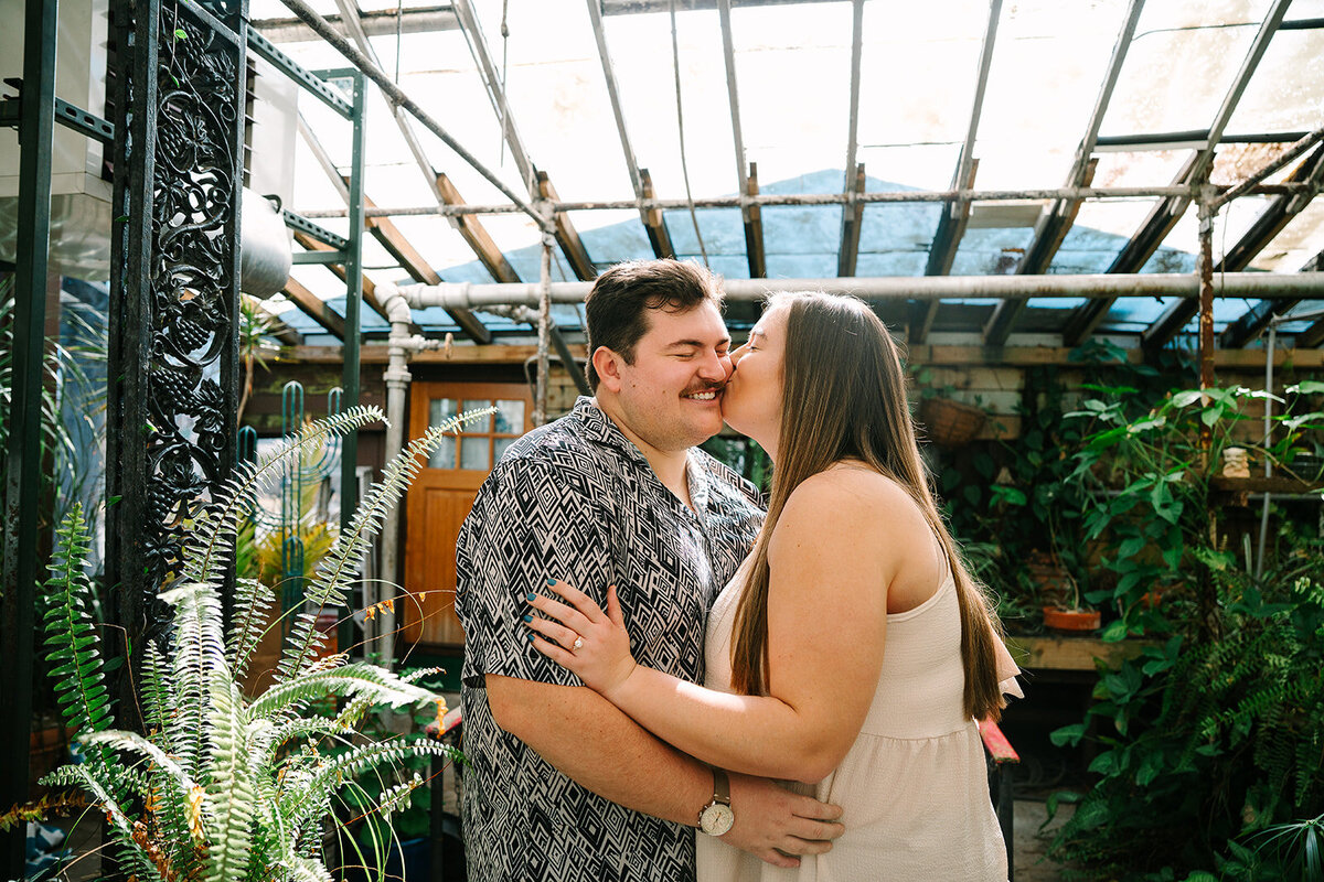 A person kissing their partner's cheek. 