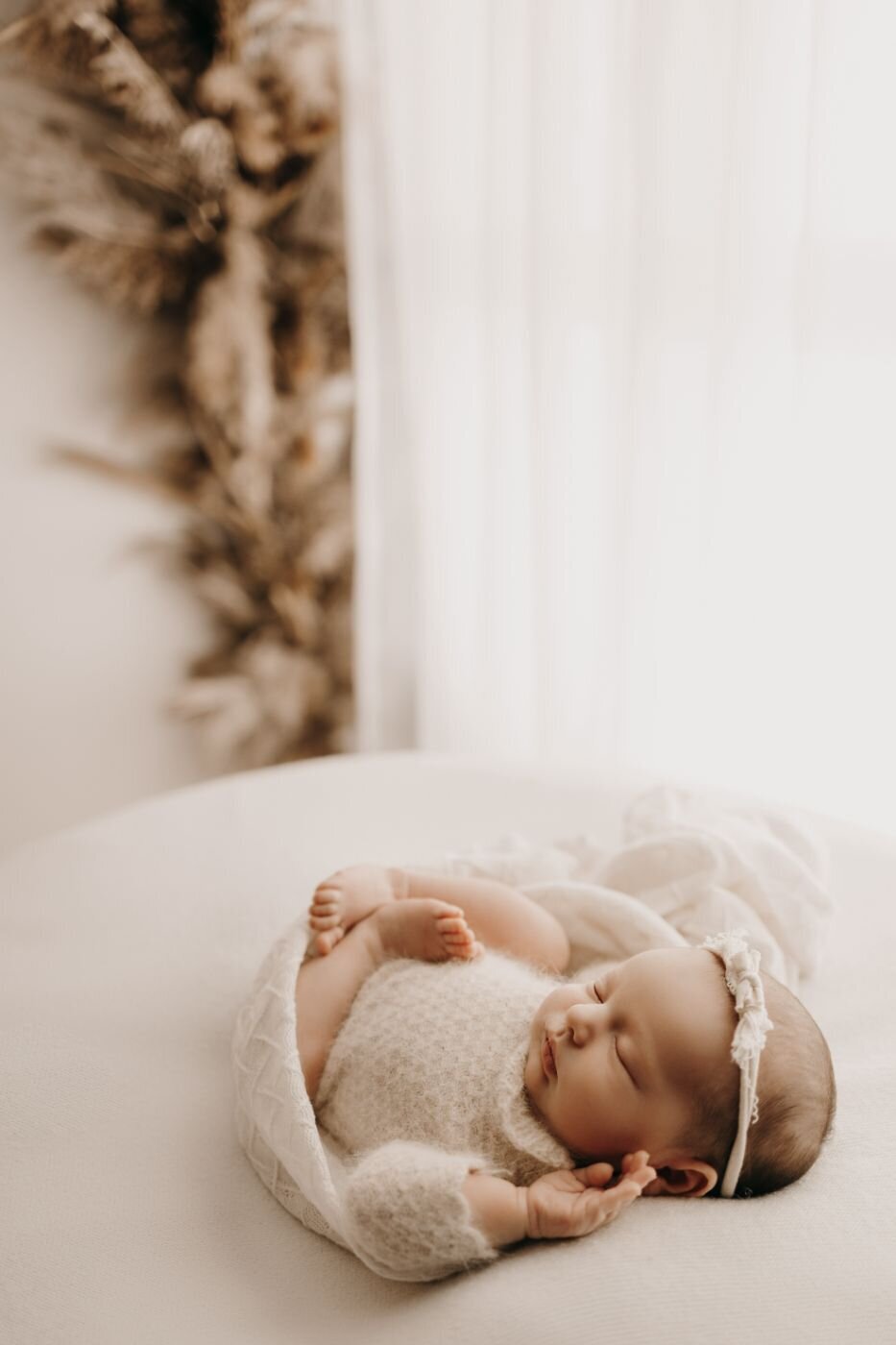 Beautiful sleeping newborn baby girl with a delicate headband during a Mullingar photoshoot