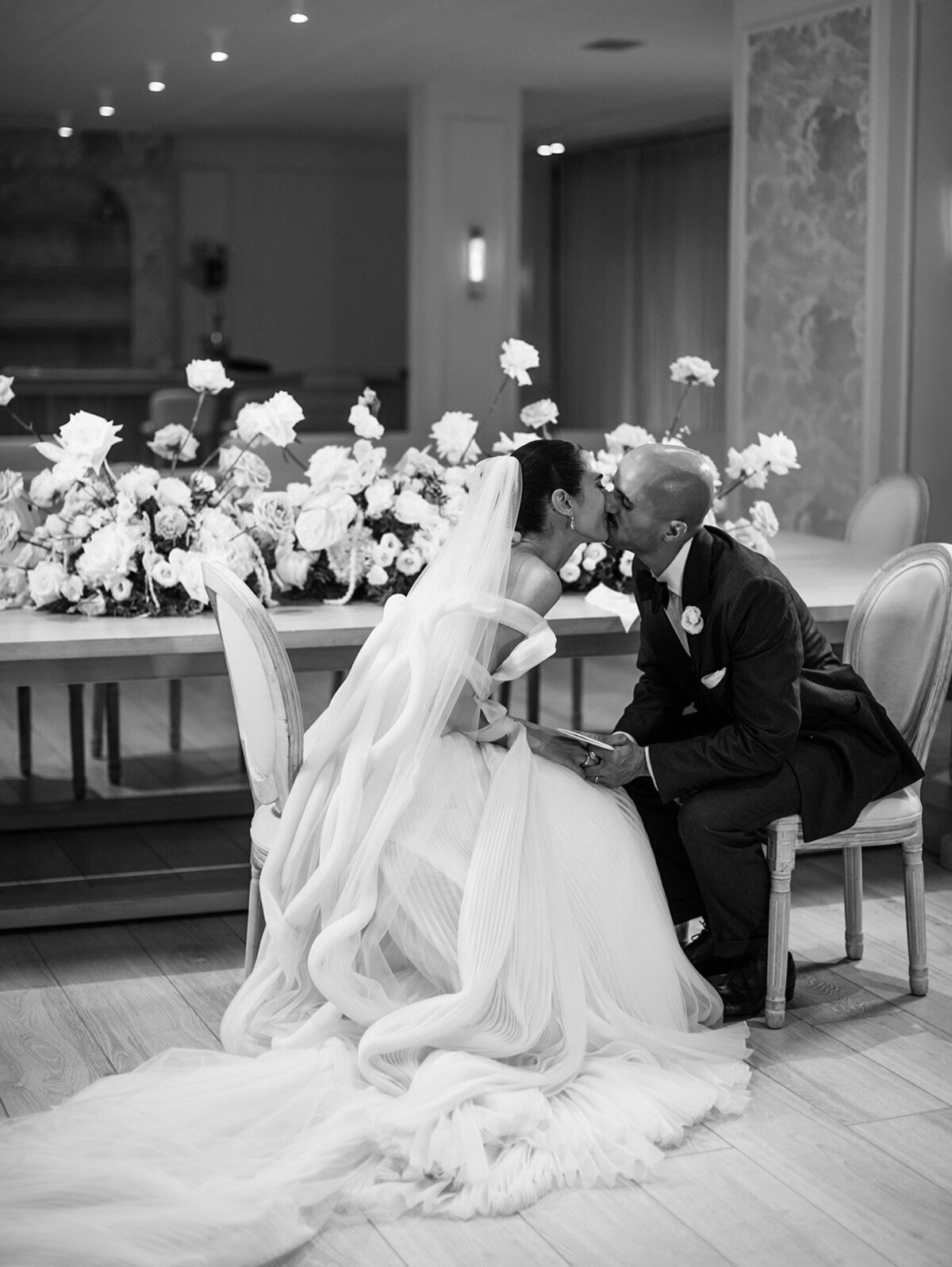 bride and groom kiss while signing marriage certificate