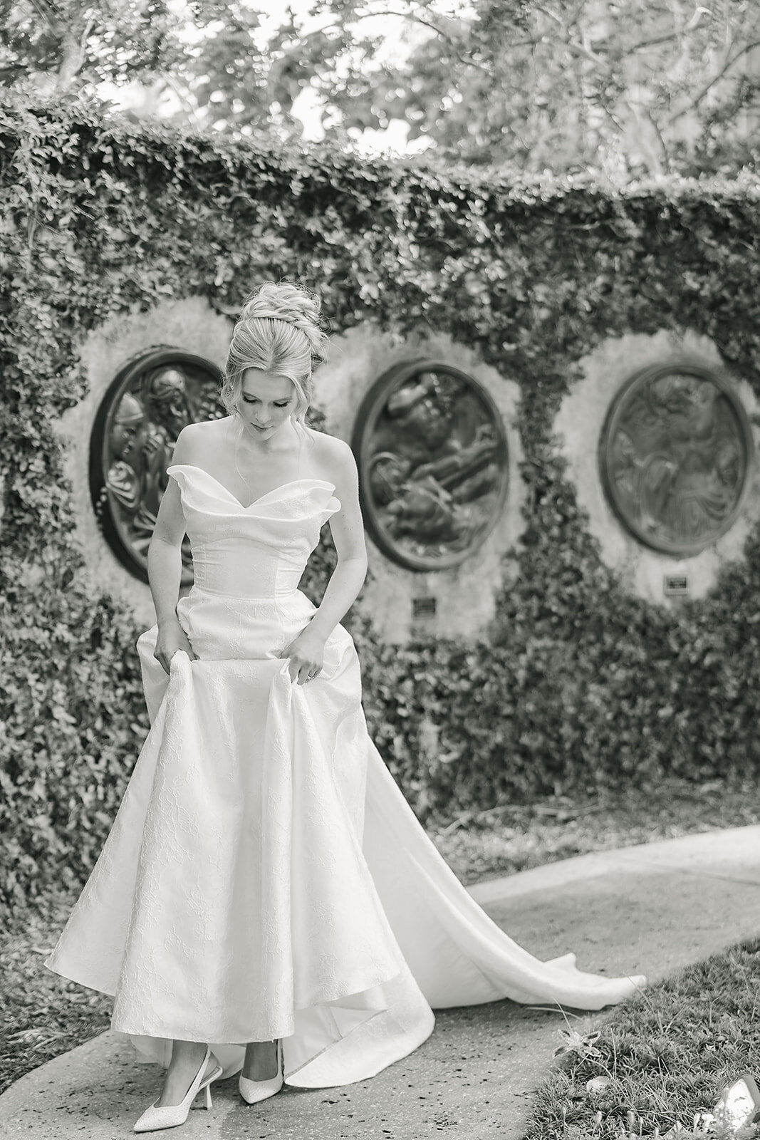 Bride in wedding dress walking through The Capen House in winter park garden.