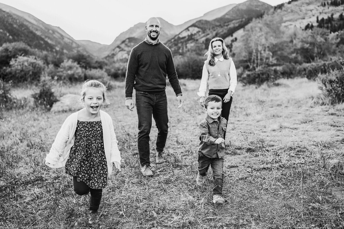 Colorado family running together in a mountain field having fun