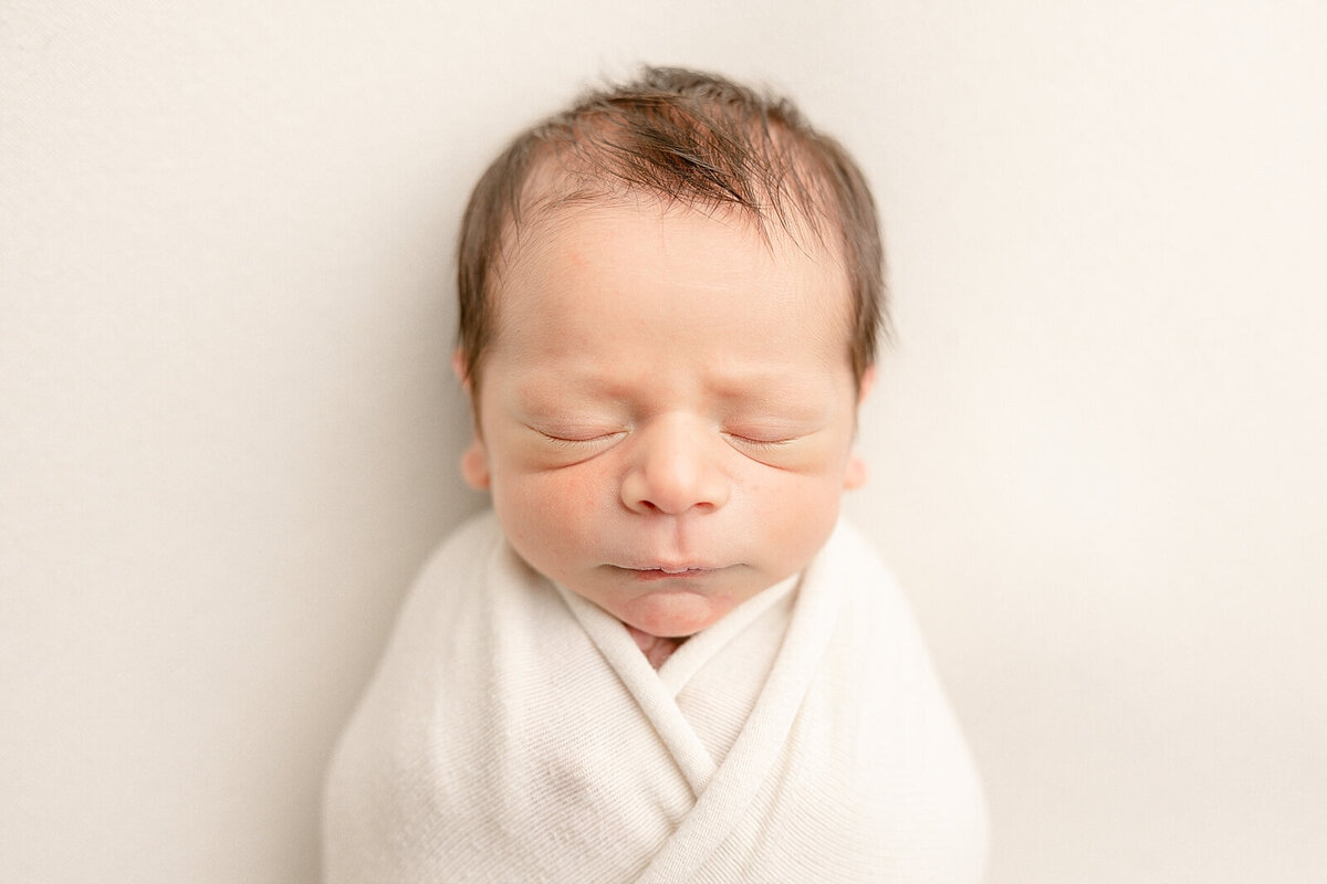 baby boy wrapped on white backdrop