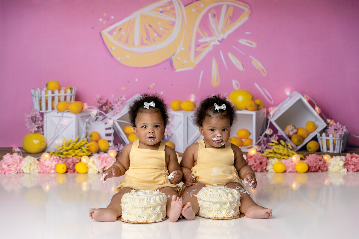 Twins smile in a lemondae themed cake smash session