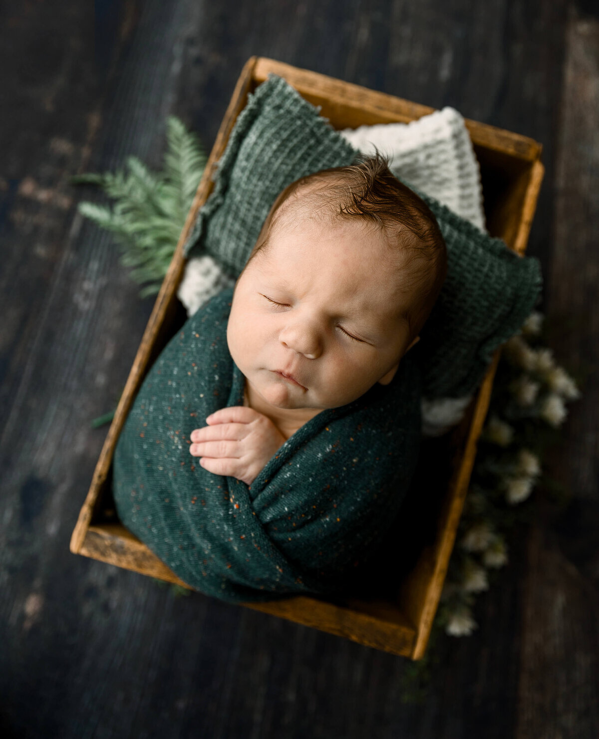 Newborn boy wrapped in green