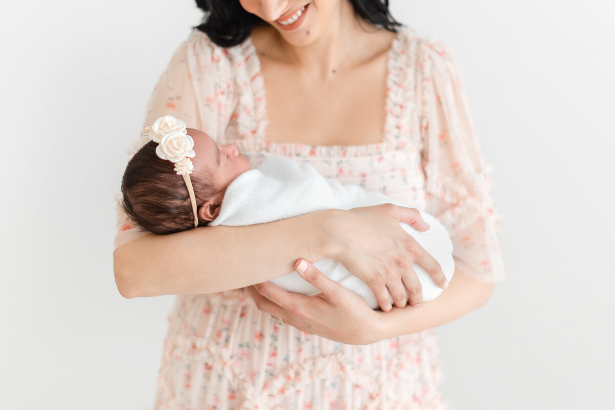 A closeup of a baby girl in her mother's arms at her Nova Studio Photography photoshoot