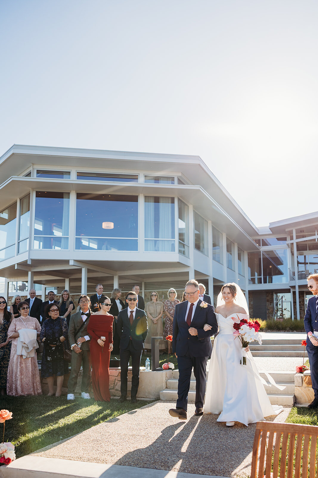 Bride being walked down the aisle with her dad. The Marion wedding venue shown in the background