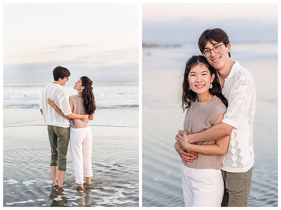 engaged couple standing in ocean