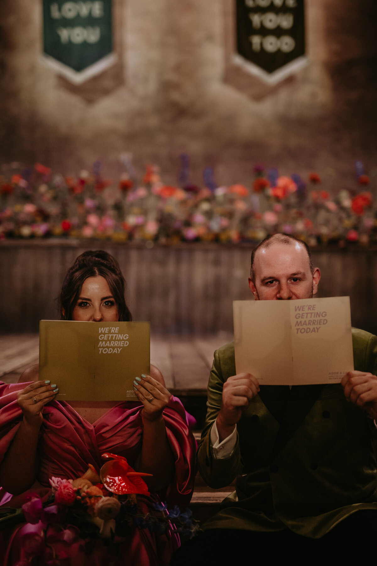 Bride and Groom pose with their wedding stationery before their ceremony at Wilton's Music Hall. 