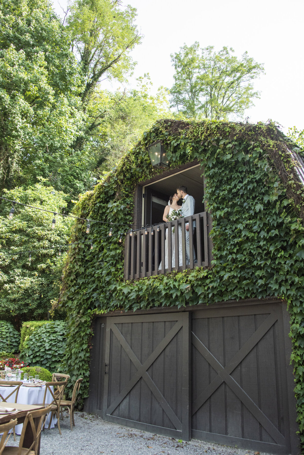 Couple standing on barn balcony at Hawkesdene