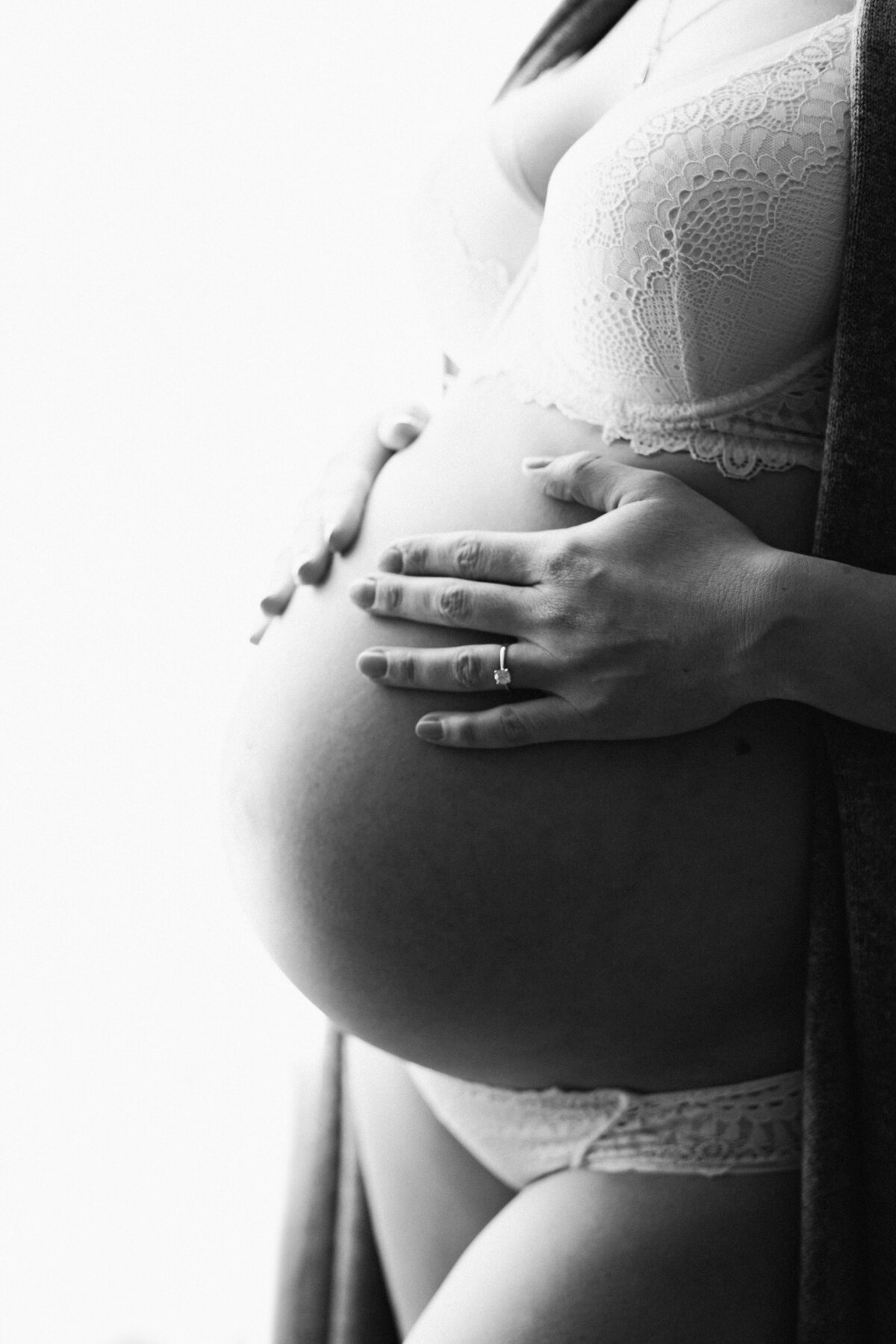 A close up of a mother holding her pregnant belly at maternity photoshoot in west sussex