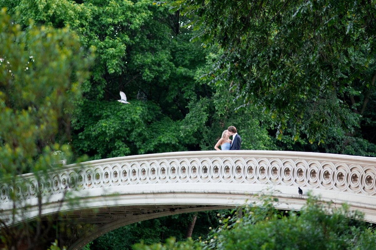a couple kissing on Bow Bridge