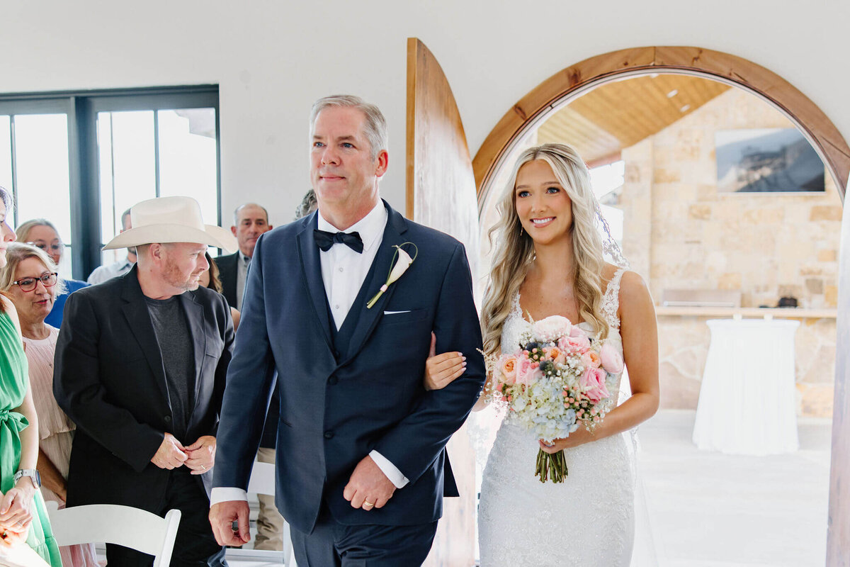 father walking daughter down aisle of wedding chapel on wedding day