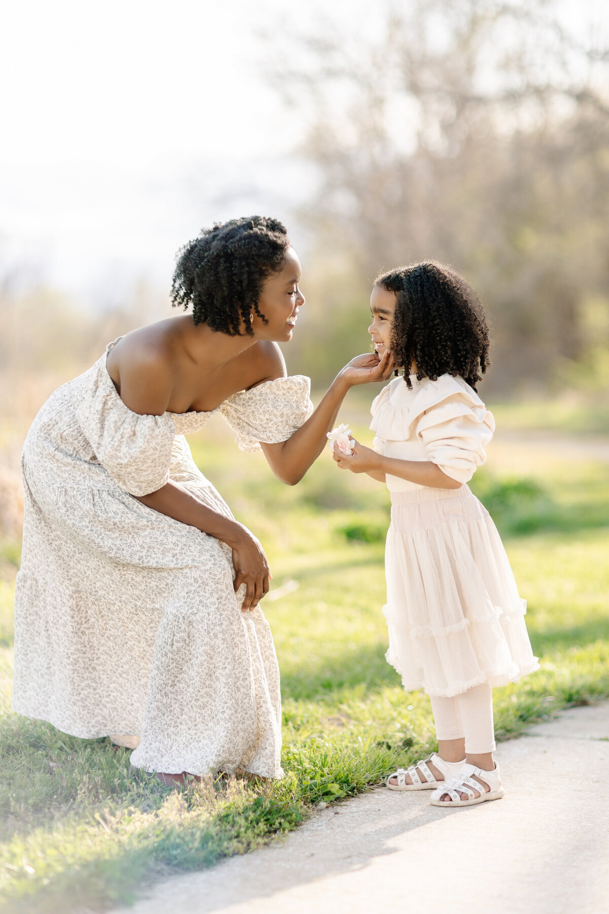 Mom in white dress holding her baby upside down at their family photos by Kansas City photographer Jeanna Hayes