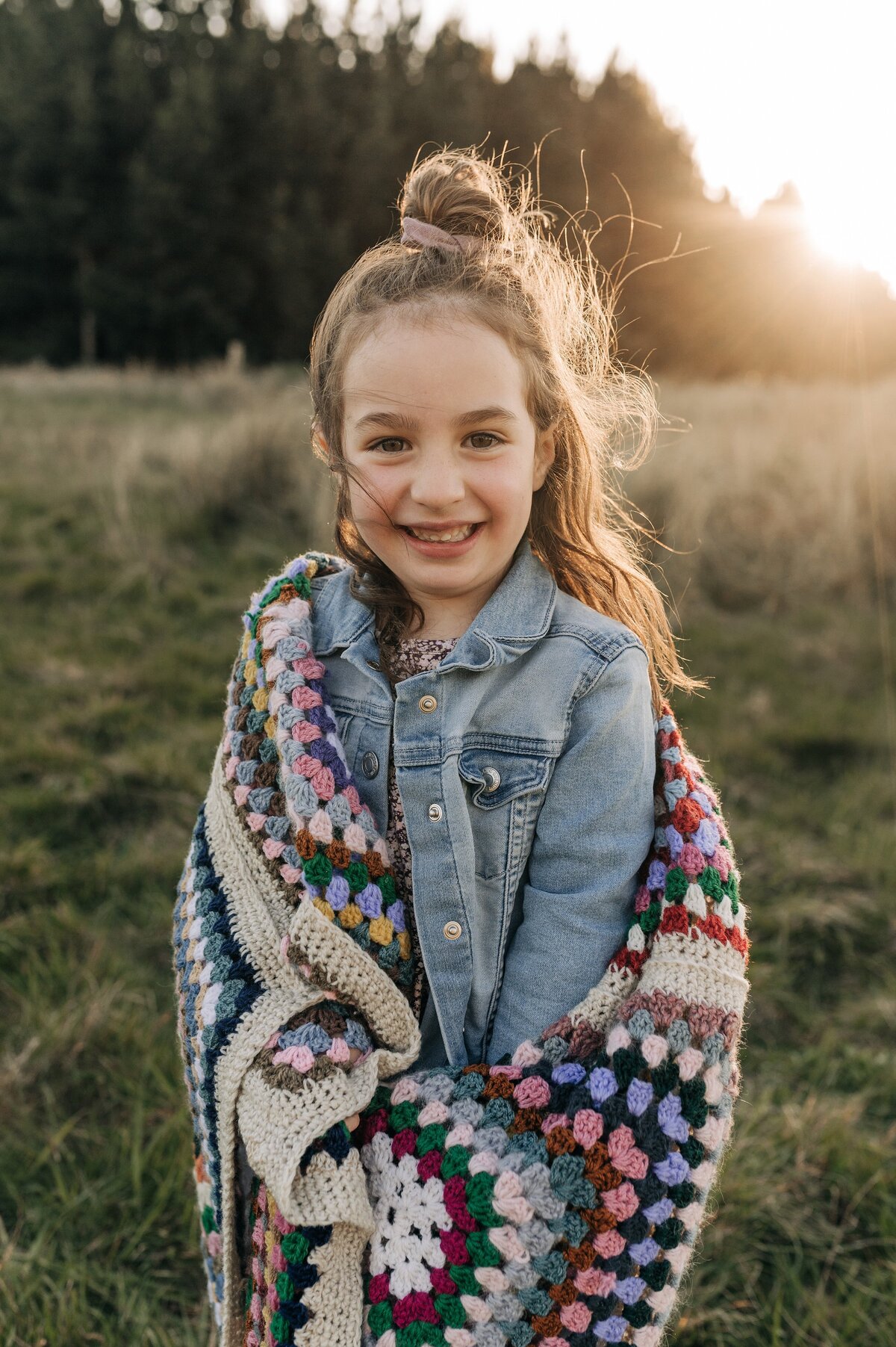 girl with crochet blanket sunset long golden grass denim jacket christchurch family portraits location ideas