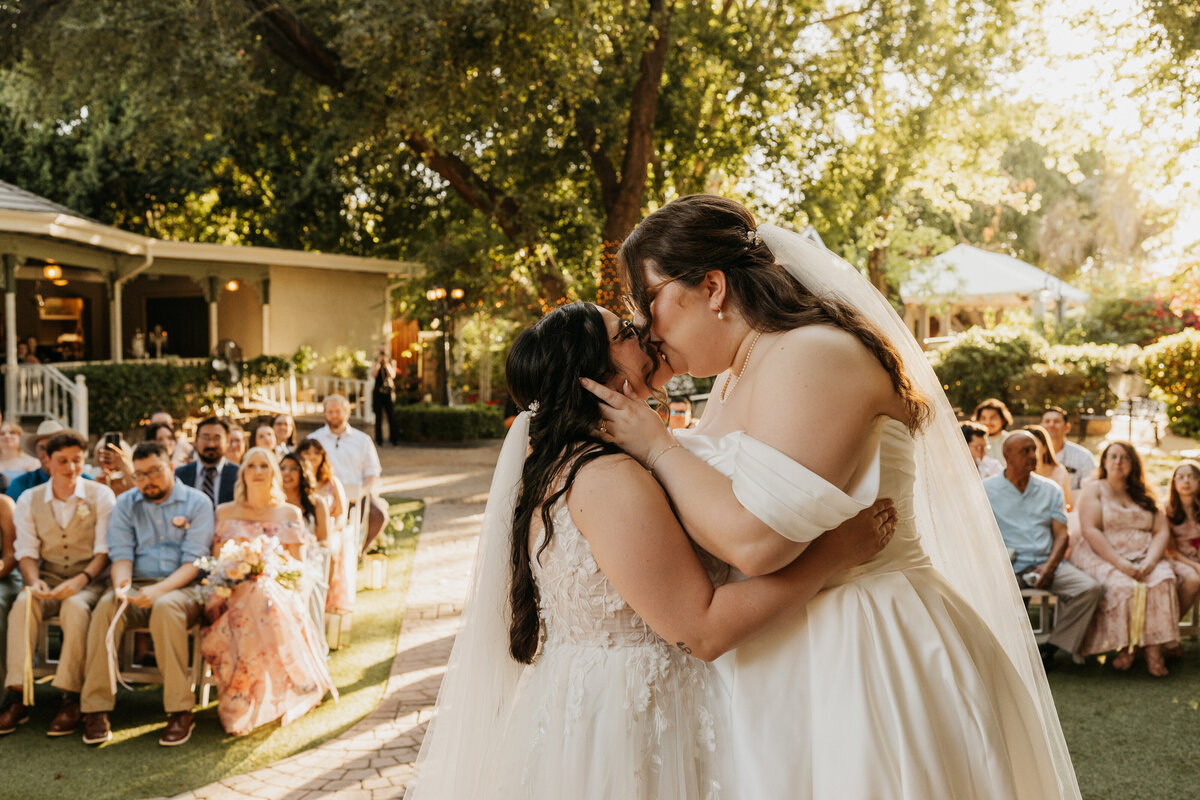 A newlywed couple during their first kiss at their wedding 