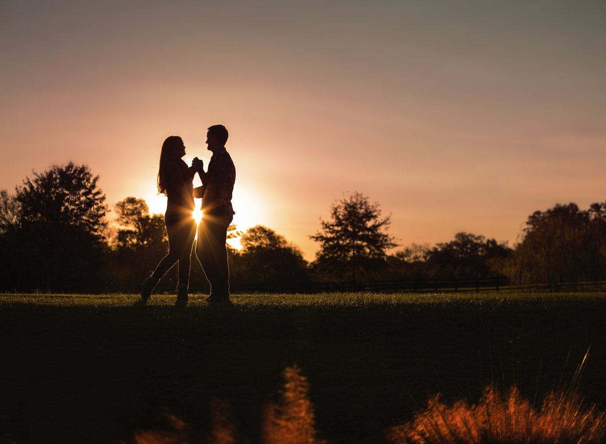 charlotte engagement photographer jamie lucido at Morning Glory Farm at sunset creates a beautiful silhouette of engaged couple dancing