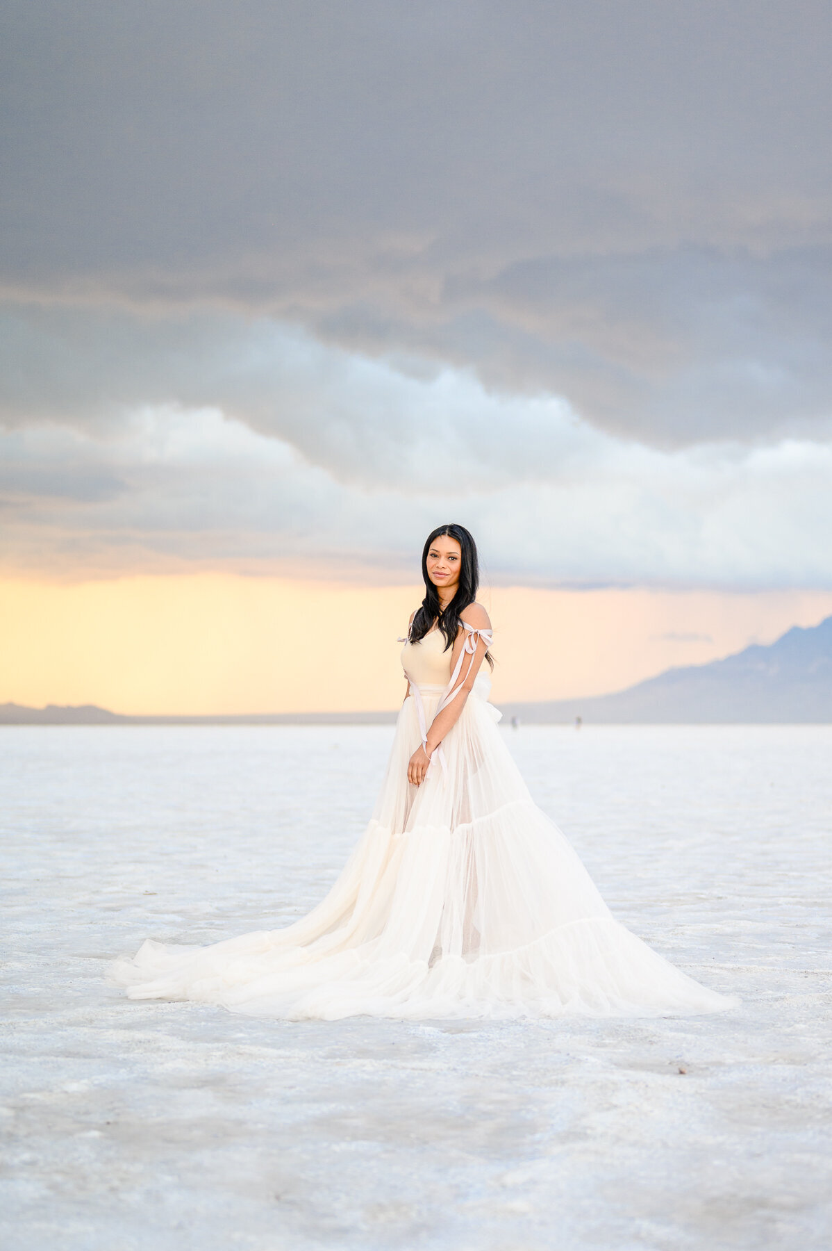 black women in white dress posing at sunset at the salt flats utah 
