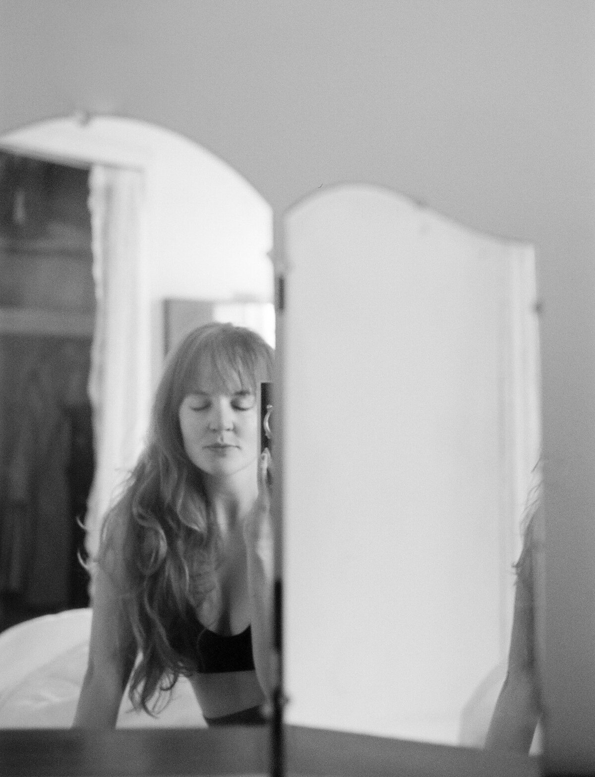 soft self portrait of female photographer, long hair in vanity mirror, vintage rangefinder camera