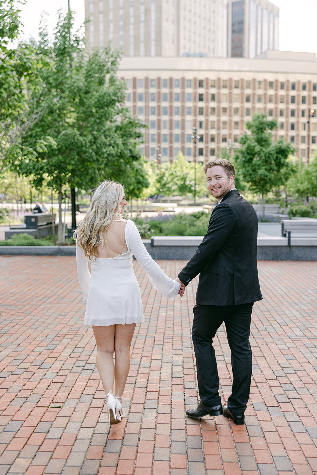 a couple holding hands while walking in Boston