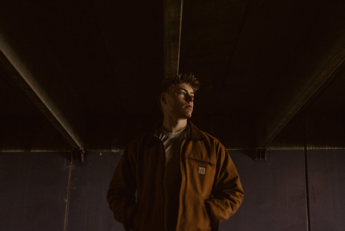 highschool male senior in stands in parking garage 