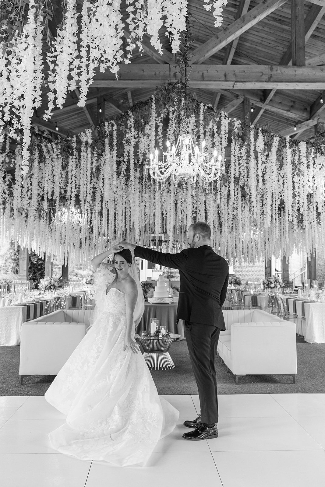 bride and groom first dance under flowers on dance floor