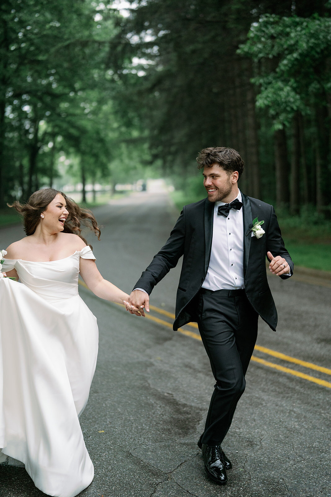 Joyful candid photo of bride and groom running outside The Morris Estate during their wedding portraits.