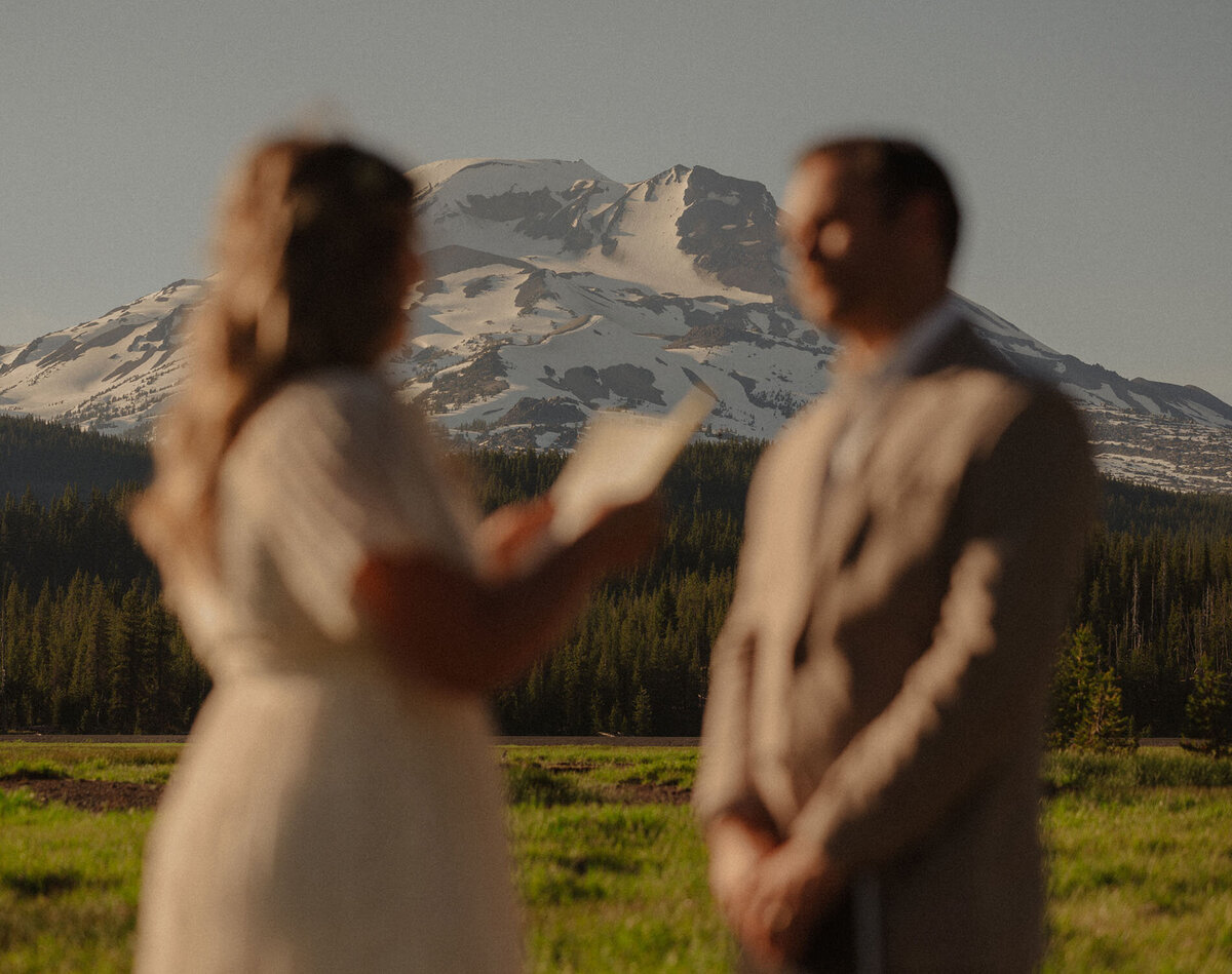 engagement couple exchanging vows in front of Mt. Bachelor during a sunny day in Bend, Oregon