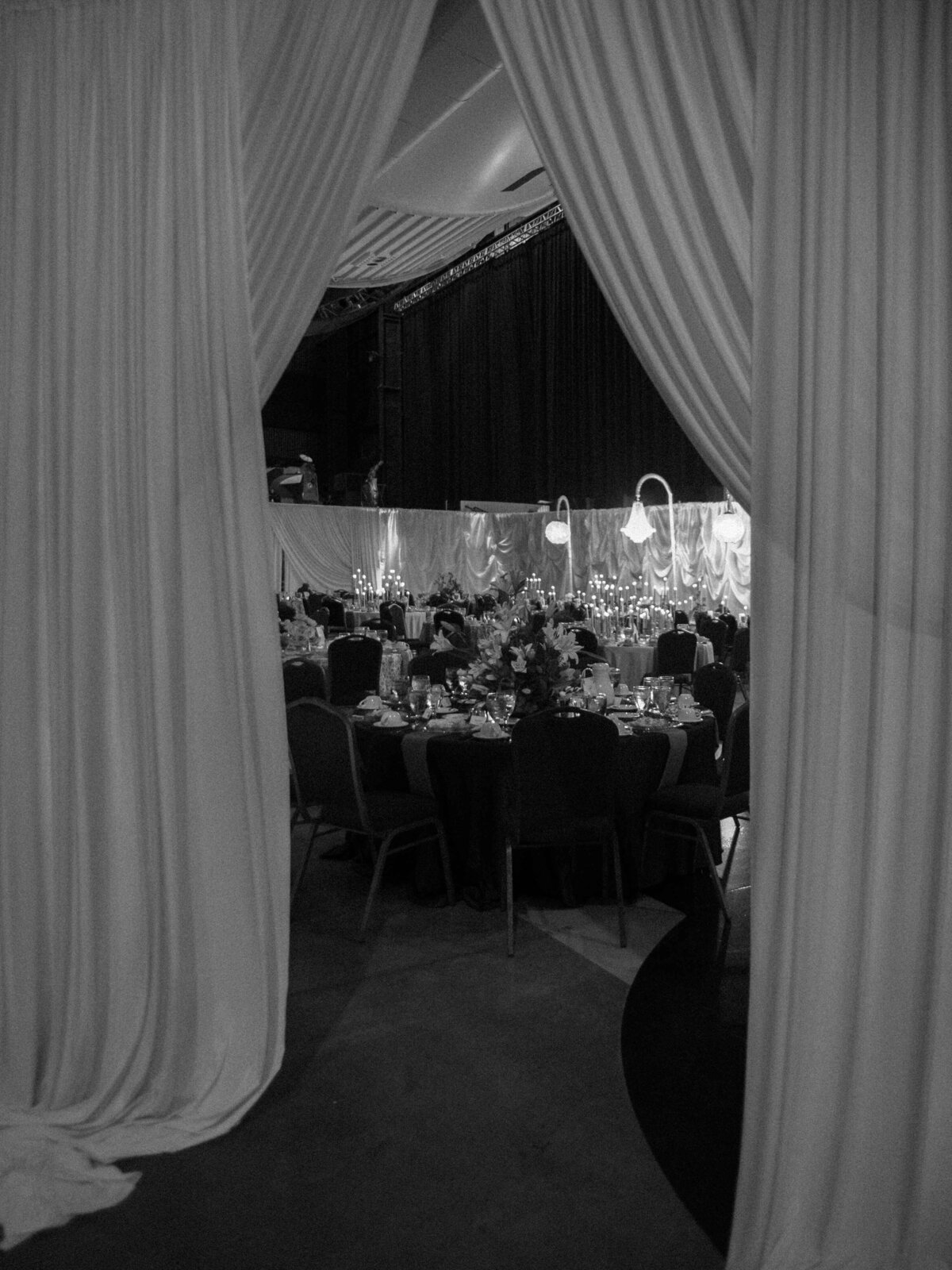 Black and white photo of a draped entrance leading into a wedding reception at the U.S. Space and Rocket Center in Huntsville, Alabama.