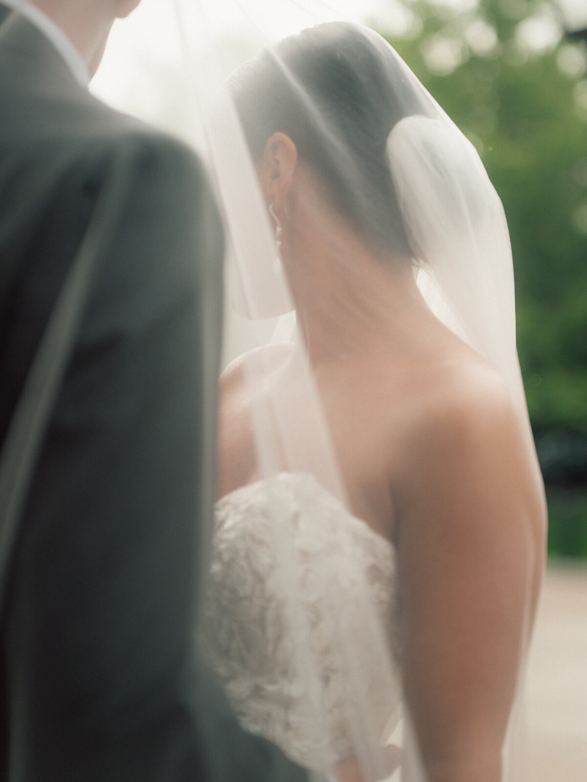 Bride in strapless gown and soft veil during intimate wedding moment outdoors