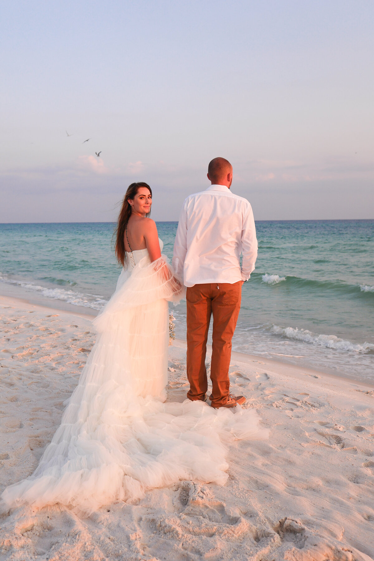 bride and groom holding hands on Panama City Beach at sunset by Destin Florida elopement photographer Amanda Richardson Photography