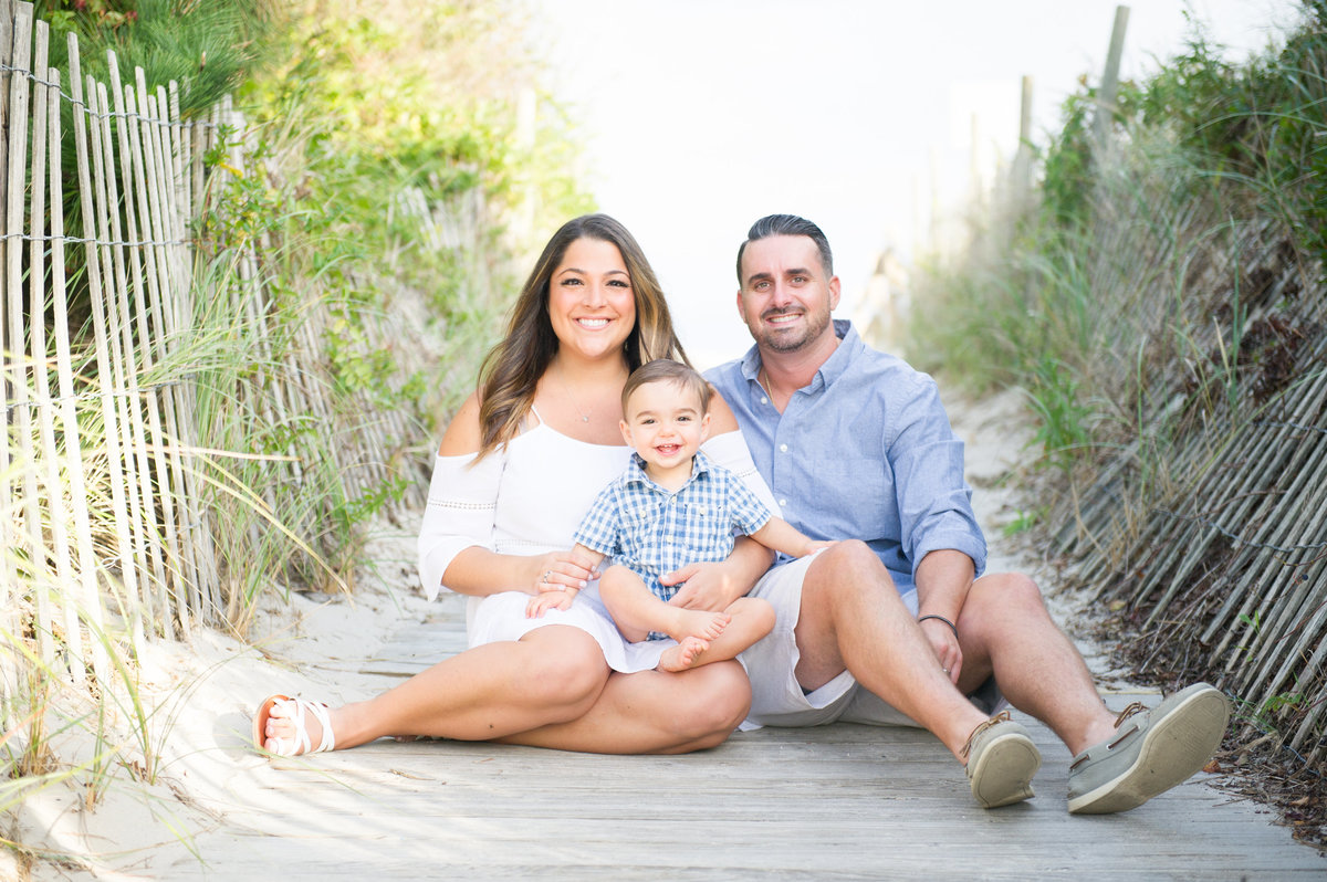 family of three sitting at beach