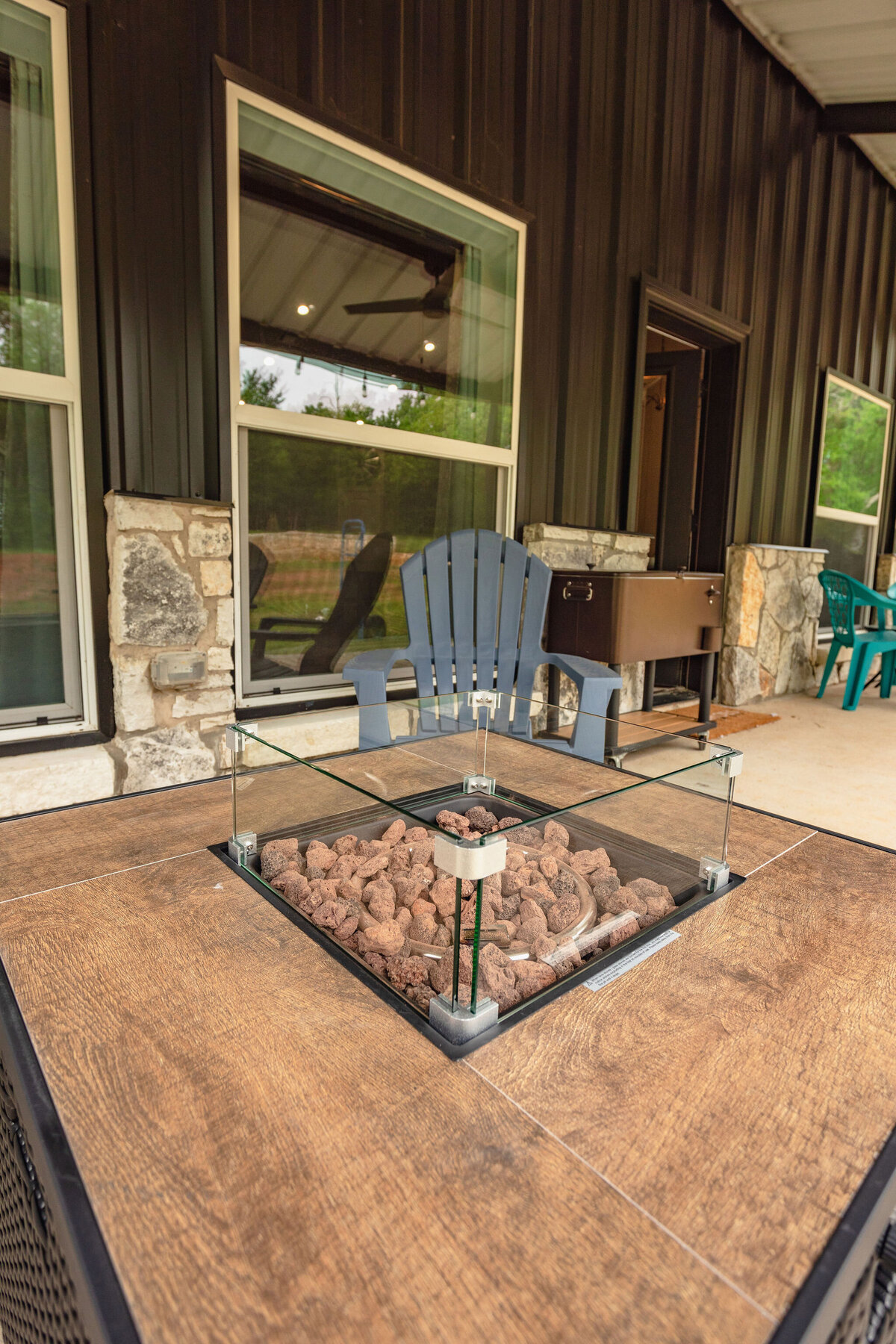 Outdoor patio with firepit and plenty of seating at this five-bedroom, 3-bathroom vacation rental house for up to 10 guests with free wifi, private parking, outdoor games and seating, and bbq grill on 2 acres of land near Waco, TX.