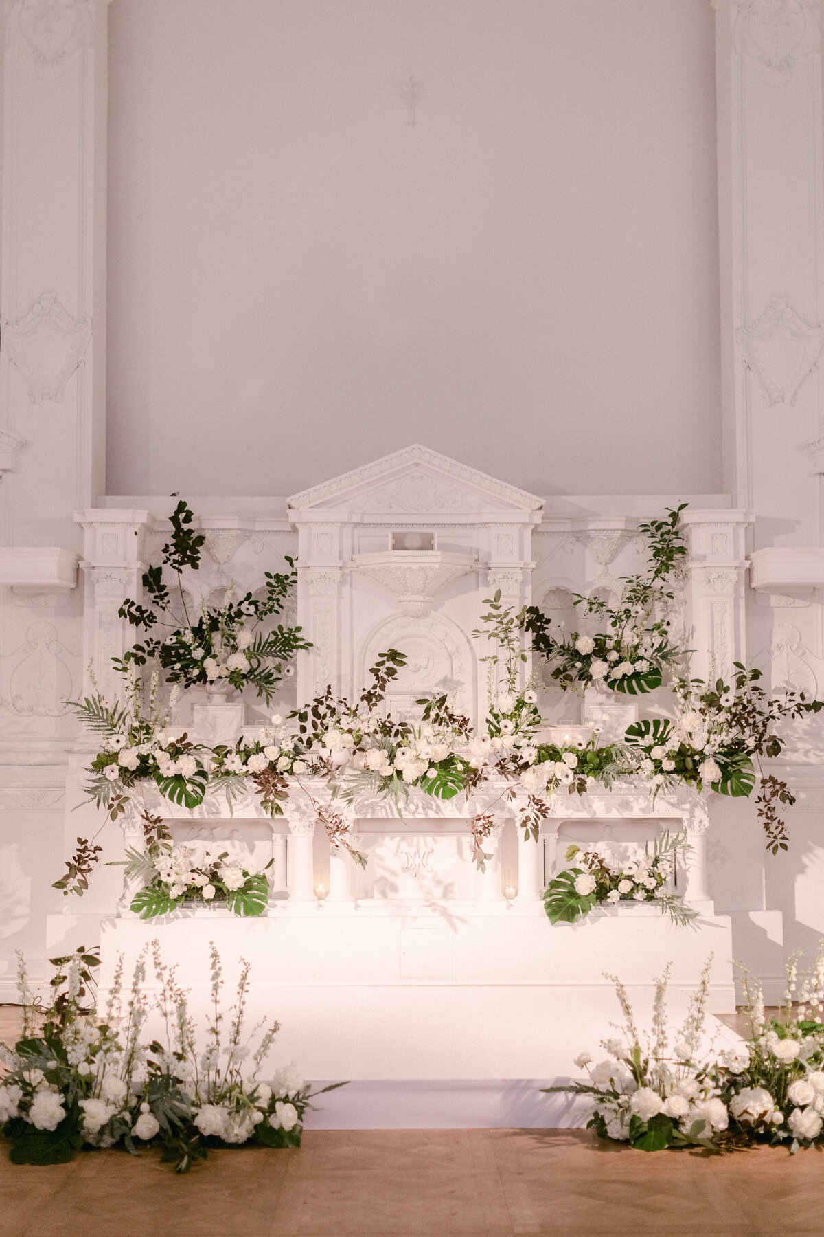 Elaborate, exotic greenery and white flower arrangements at Maison Principale for a wedding ceremony.